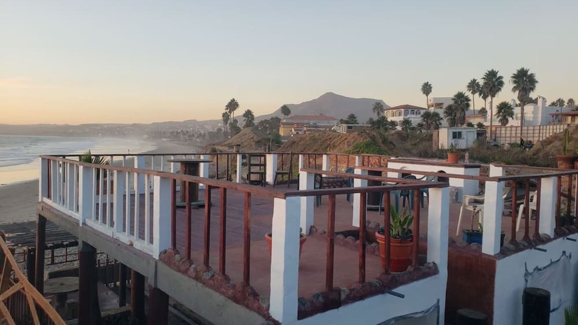Rooftop terrace overlooking the coastline with outdoor seating and panoramic ocean views at Casa Playa Baja Resort.