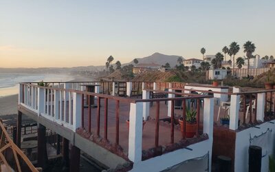 Rooftop terrace overlooking the coastline with outdoor seating and panoramic ocean views at Casa Playa Baja Resort.