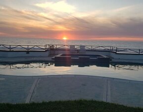 Oceanfront pool at sunset with hot tub and uninterrupted Pacific Ocean views at Casa Playa Baja Resort.