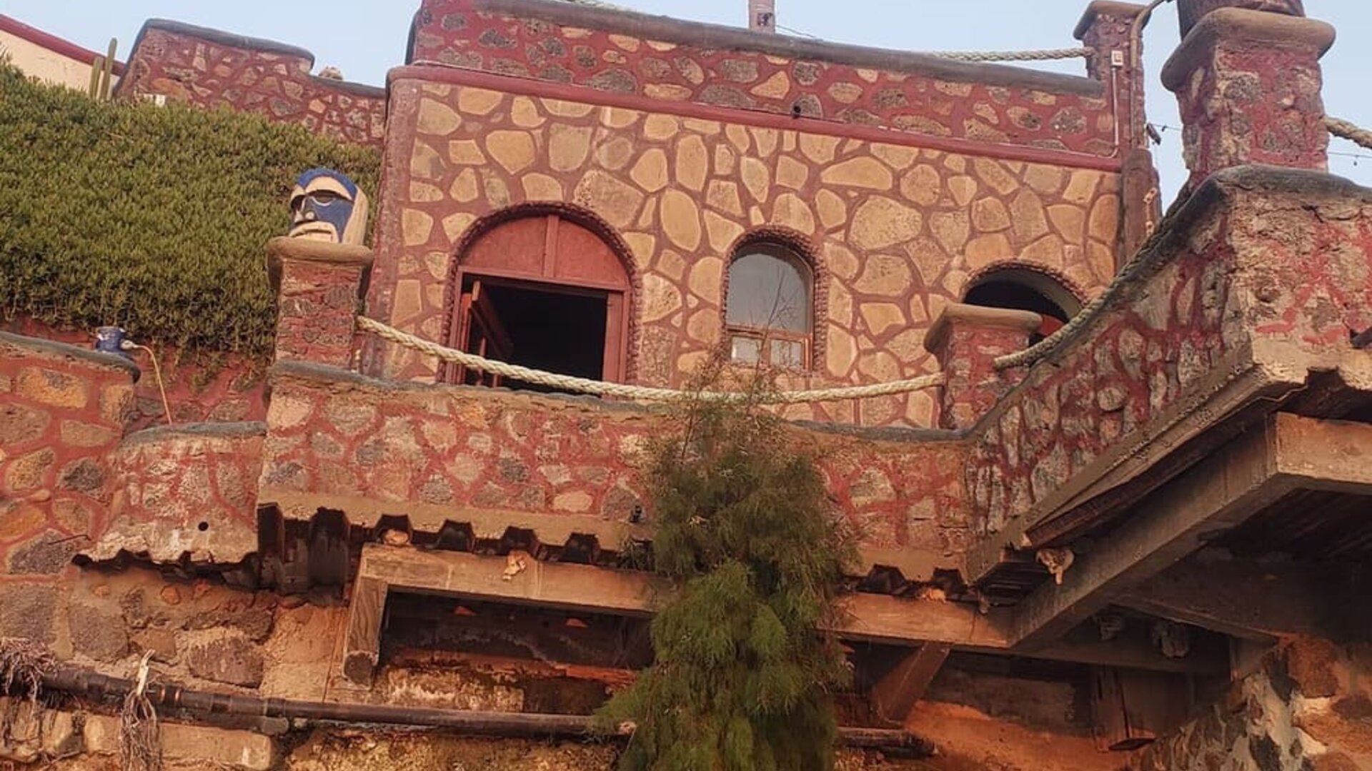 Stone-clad exterior building with arched windows and rustic architectural details at Casa Playa Baja Resort.