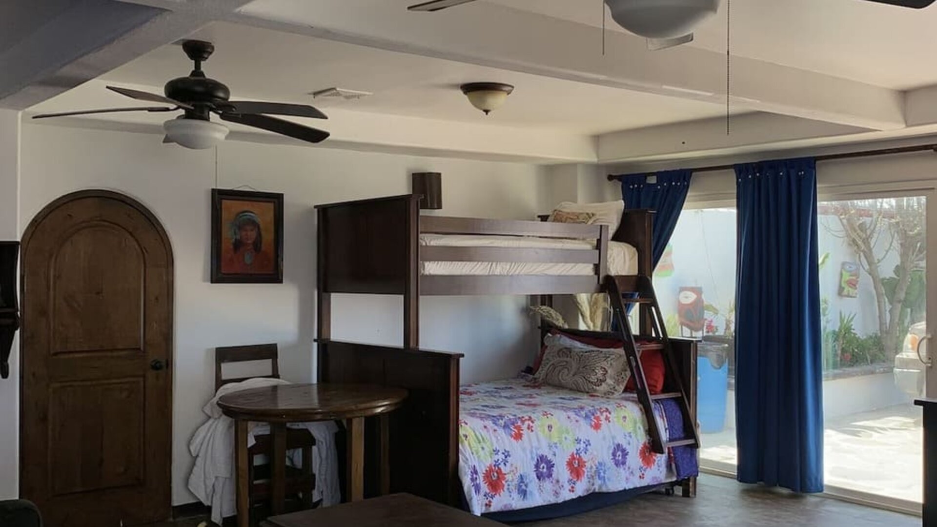 Family suite with bunk beds, lounge area, and direct access to the outdoor patio at Casa Playa Baja Resort.