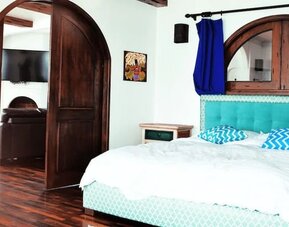 Bright king suite with green accents, large windows, balcony access, and modern furnishings at Casa Playa Baja Resort.