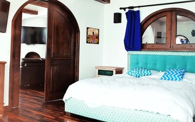 Bright king suite with green accents, large windows, balcony access, and modern furnishings at Casa Playa Baja Resort.