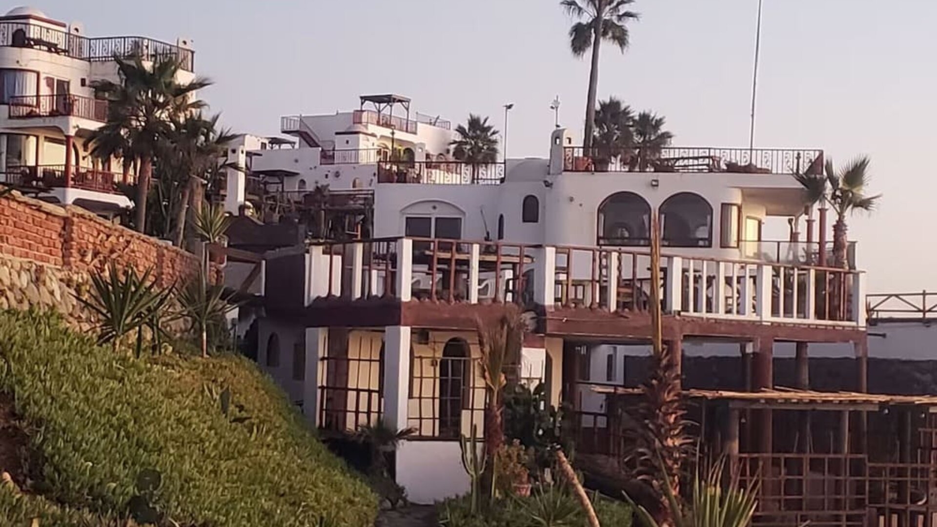 Exterior view of the beachfront resort showcasing multi-level terraces, oceanfront architecture, and landscaped grounds at Casa Playa Baja Resort.