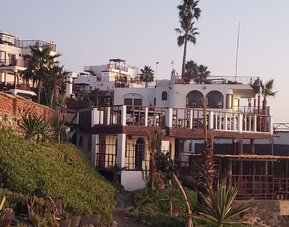Exterior view of the beachfront resort showcasing multi-level terraces, oceanfront architecture, and landscaped grounds at Casa Playa Baja Resort.