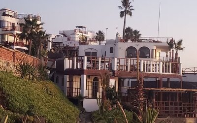 Exterior view of the beachfront resort showcasing multi-level terraces, oceanfront architecture, and landscaped grounds at Casa Playa Baja Resort.