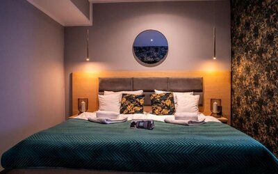 Contemporary king bedroom with feature lighting and modern furnishings at Hotel Seven.