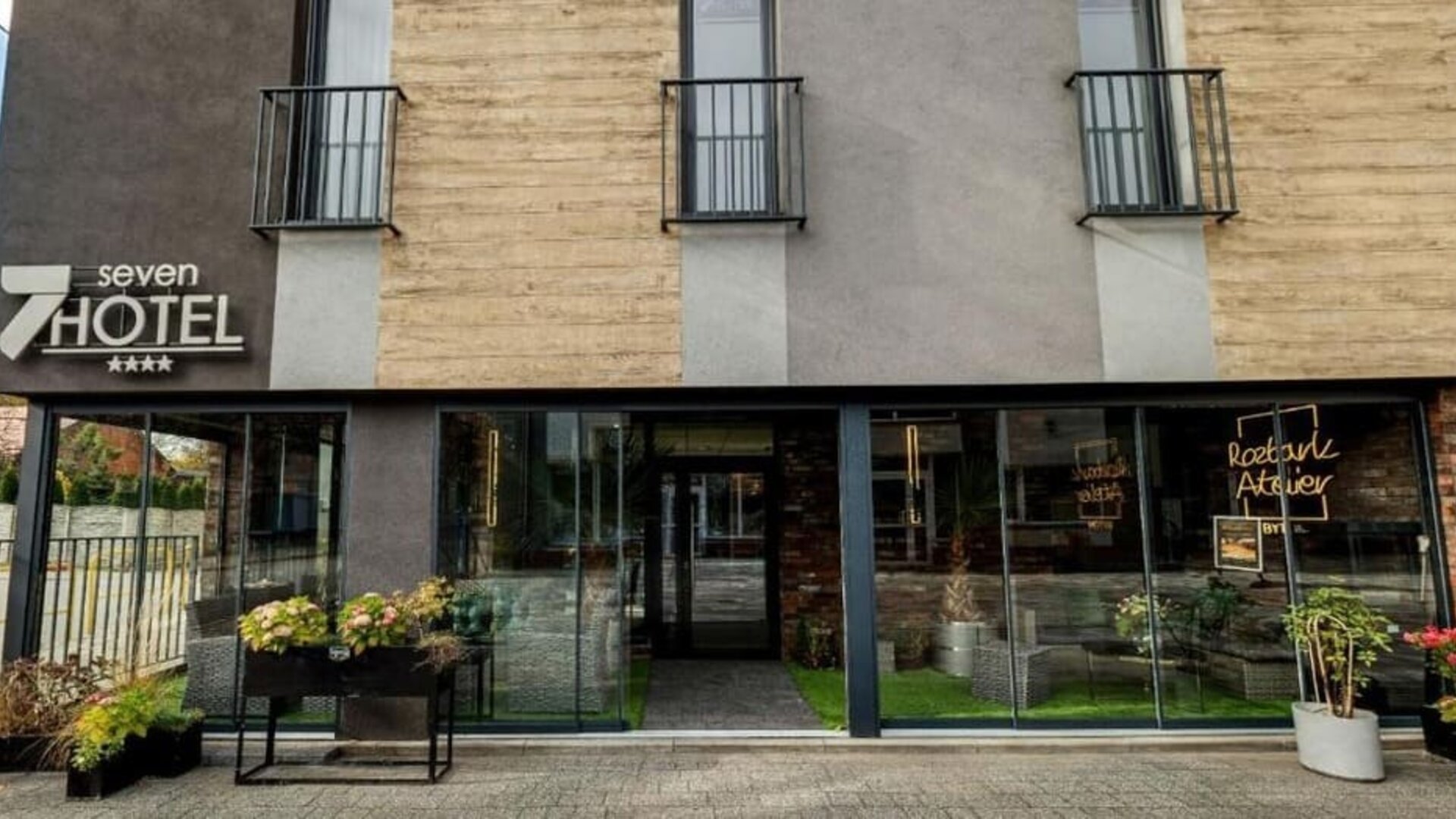 Main entrance to Hotel Seven with modern glass façade and Atelier Rozbark restaurant.