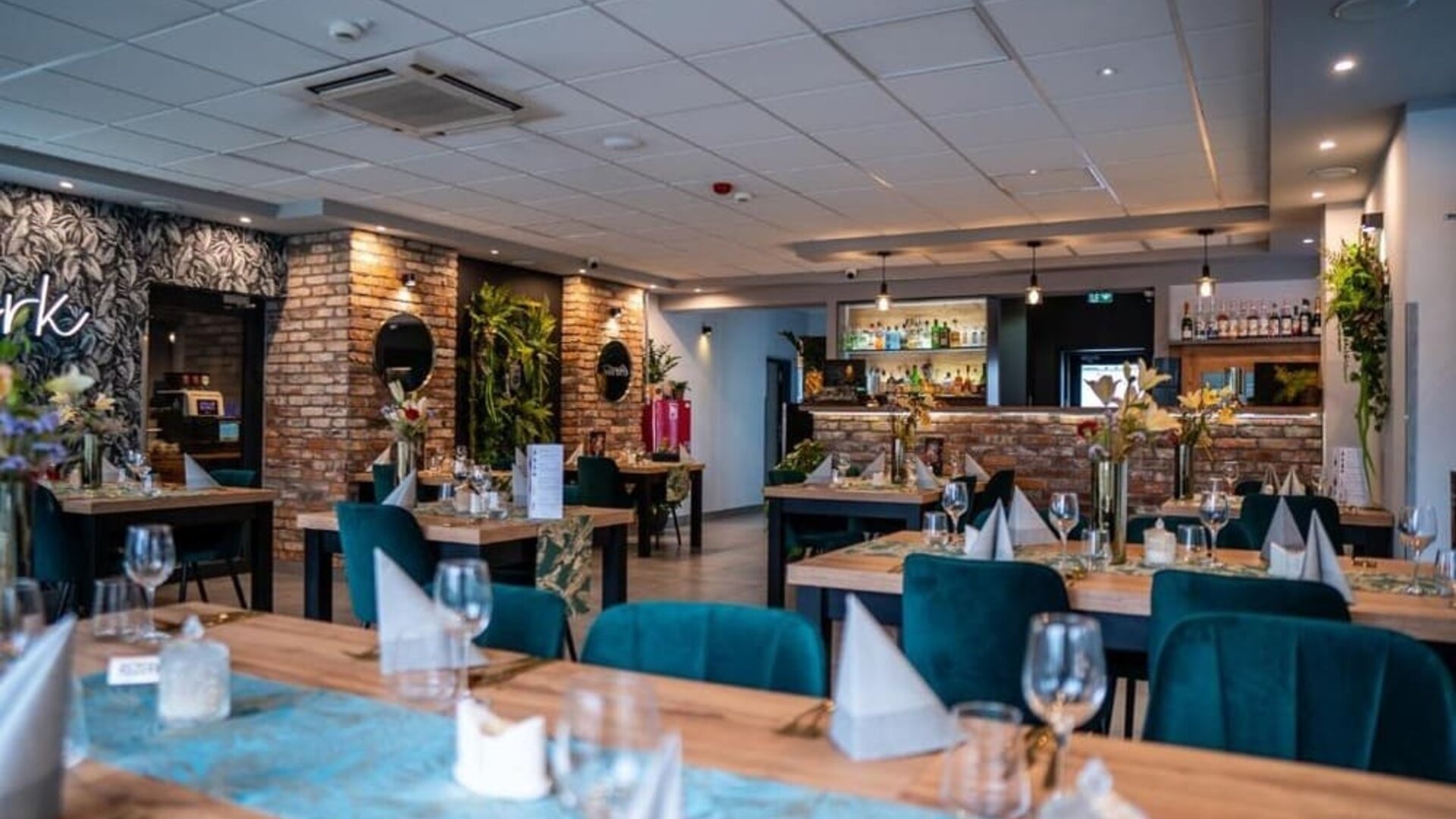Elegant restaurant with modern tables, velvet chairs and exposed brick accents at Hotel Seven.