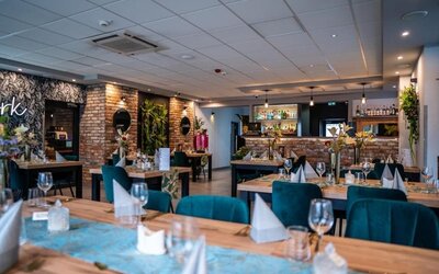 Elegant restaurant with modern tables, velvet chairs and exposed brick accents at Hotel Seven.