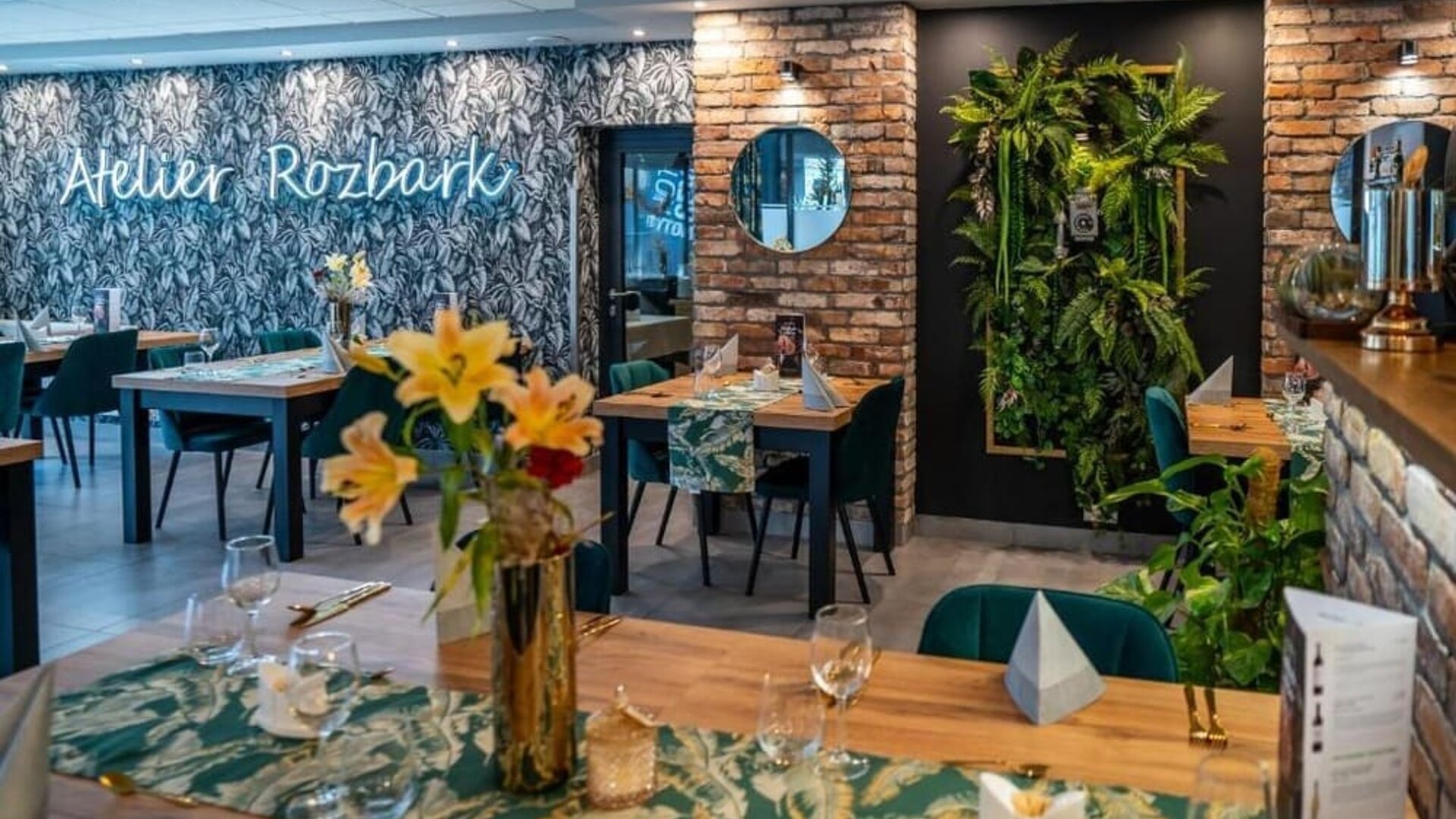 Modern hotel restaurant featuring exposed brick, greenery and elegant dining spaces at Hotel Seven.