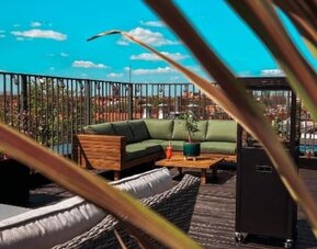 Modern rooftop lounge with outdoor furniture and open-air relaxation space at Hotel Seven.