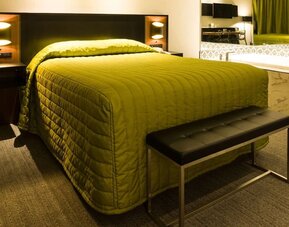 Contemporary guest room with king-size bed, open vanity and modern lighting at Le Chabrol Hotel Et Suites.