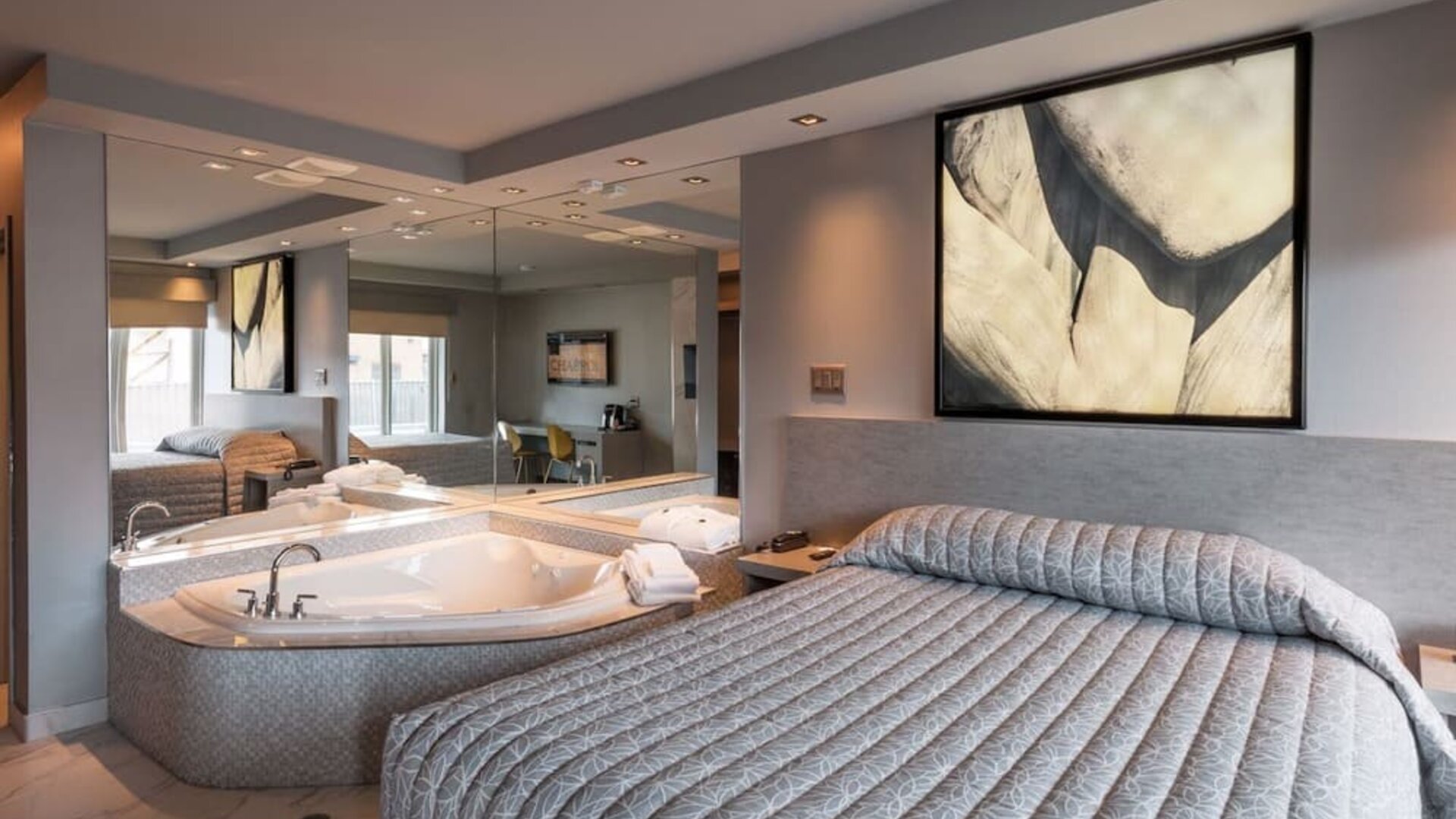 Spacious suite with king-size bed, in-room jacuzzi and contemporary décor at Le Chabrol Hotel Et Suites.