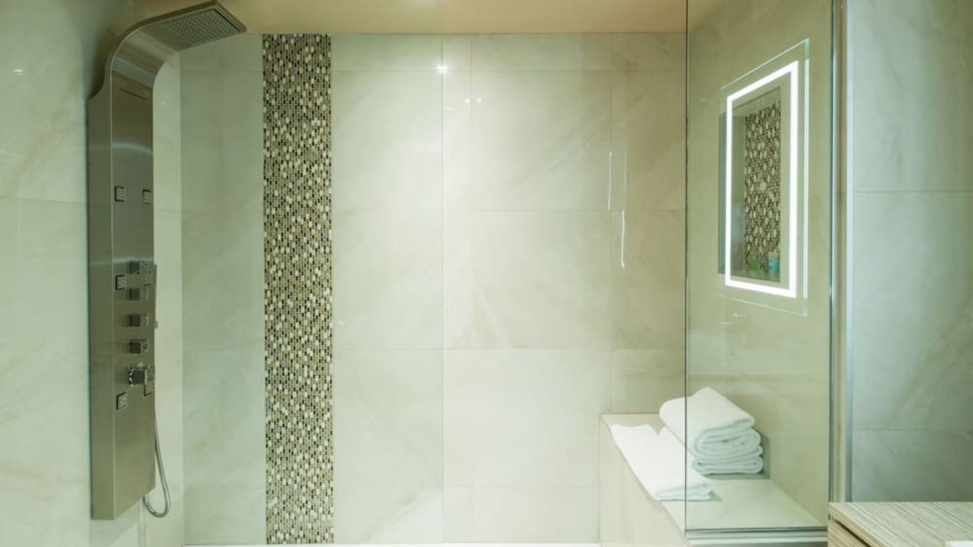 Luxury walk-in shower with rainfall showerhead and spa-inspired design at Le Chabrol Hotel Et Suites.