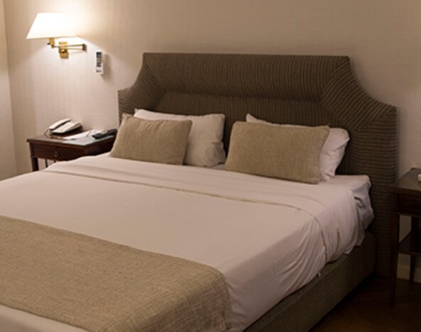 Comfortable king guest room featuring plush bedding, bedside lighting, elegant furnishings, and a spacious layout designed for rest and relaxation at Hotel Lafayette.