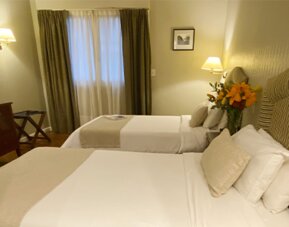 Twin guest room offering two comfortable beds, warm lighting, classic furnishings, and a relaxing atmosphere for families or friends traveling together at Hotel Lafayette.