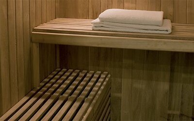 Traditional wooden sauna offering a relaxing wellness experience with tiered seating and a warm, inviting atmosphere at Hotel Lafayette.