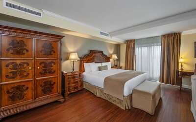 Comfortable king guest room with elegant furnishings and large wardrobe at Hotel Brossard.