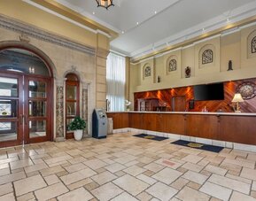 Welcoming hotel reception area with front desk and spacious lobby at Hotel Brossard.