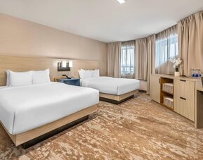Spacious guest room with two queen beds and contemporary furnishings at Comfort Inn Laval.