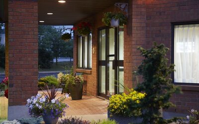 Welcoming front entrance surrounded by landscaped gardens at Comfort Inn Laval.
