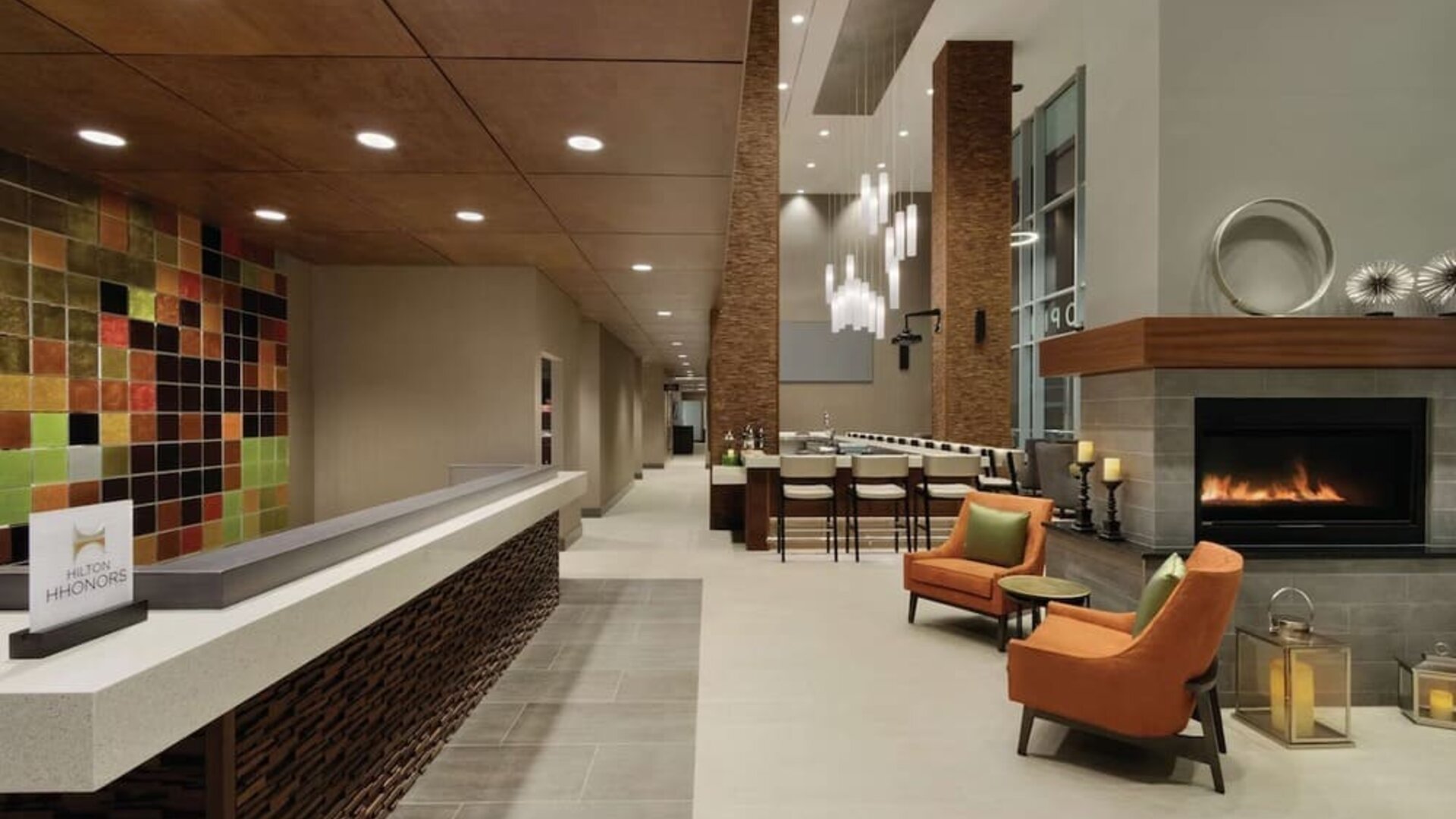 Stylish hotel lobby with fireplace, comfortable seating and modern reception area at Hilton Garden Inn Calgary Downtown.