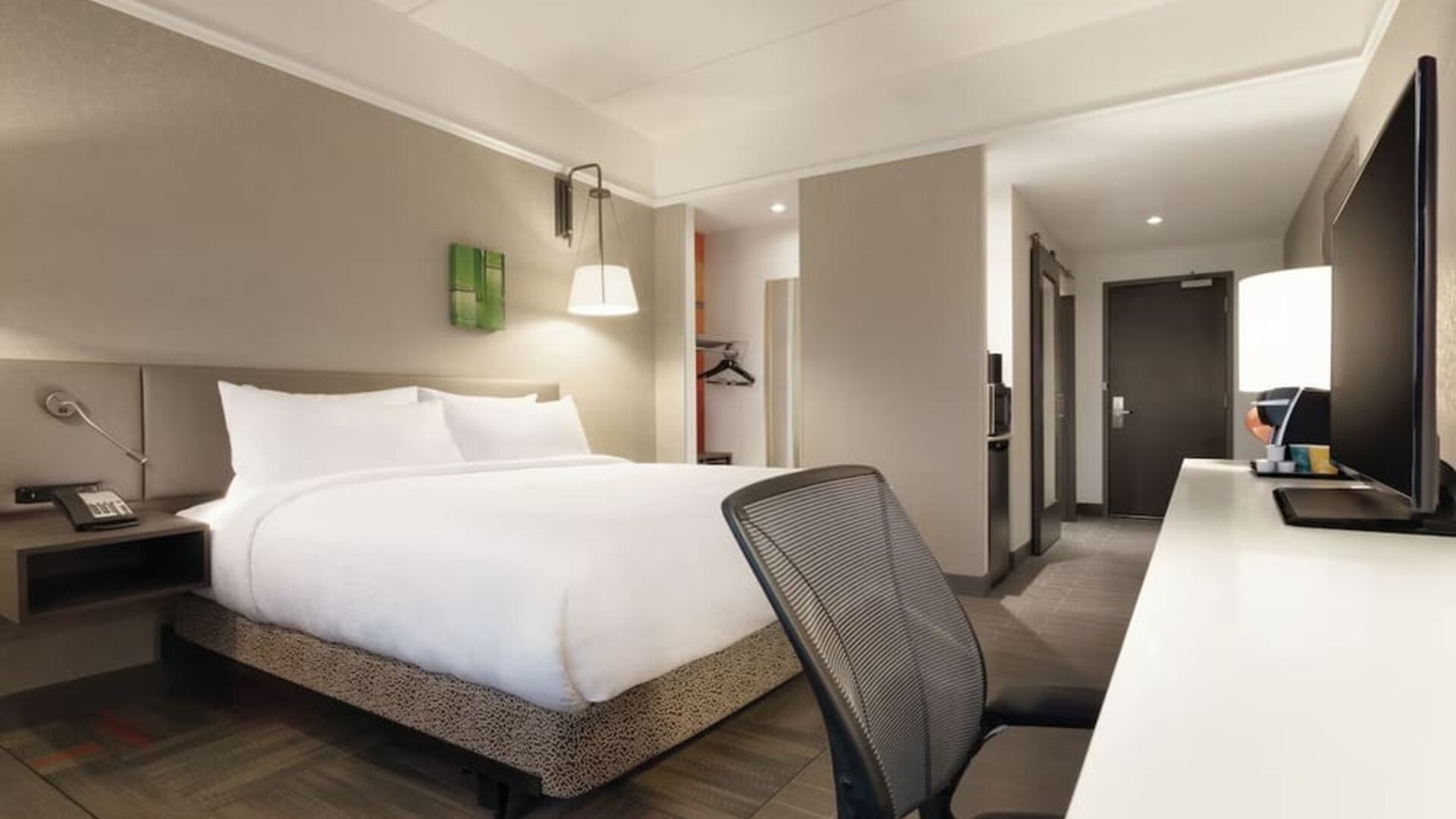 Contemporary king guest room with ergonomic workspace, HDTV and modern amenities at Hilton Garden Inn Calgary Downtown.