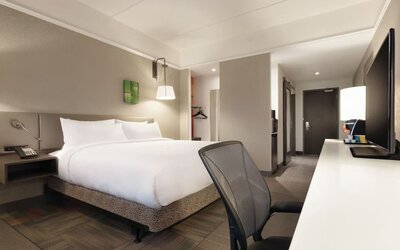 Contemporary king guest room with ergonomic workspace, HDTV and modern amenities at Hilton Garden Inn Calgary Downtown.
