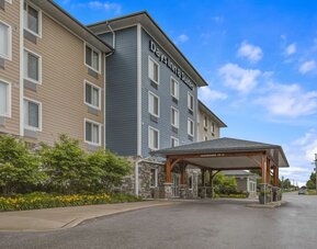 Exterior view of Days Inn & Suites By Wyndham Lindsay with landscaped entrance and covered driveway.