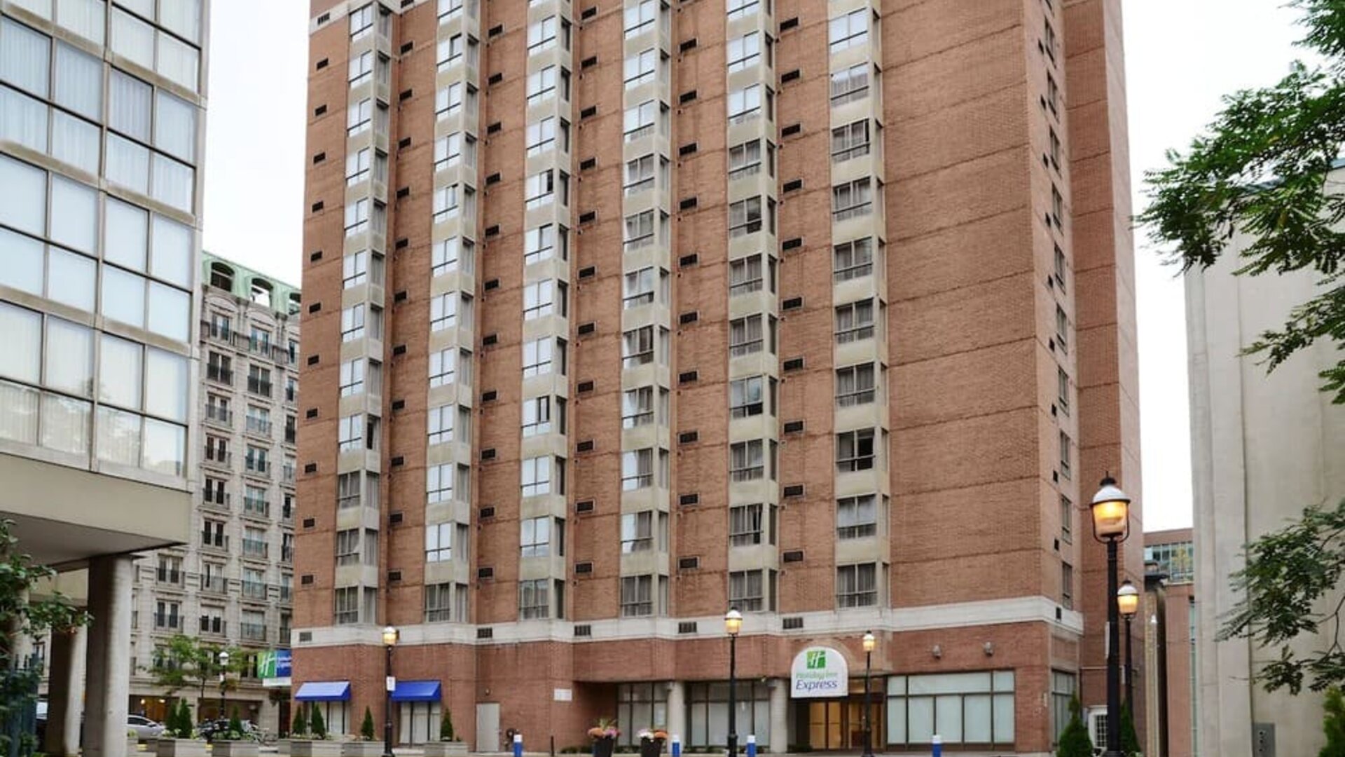 Exterior façade of Holiday Inn Express Toronto Downtown surrounded by the city's business and entertainment district.