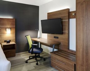 In-room workspace with ergonomic chair, flat-screen TV and ample storage at Holiday Inn Express Toronto Downtown.