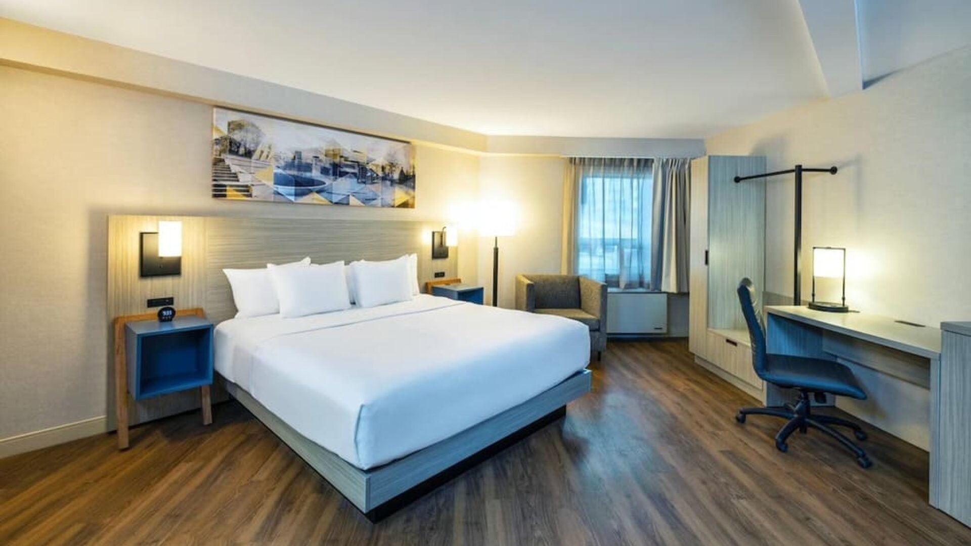 Spacious king guest room with plush bedding, ergonomic workspace, comfortable seating, and modern furnishings at Comfort Inn Amherst.