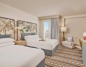 Bright guest room with two comfortable beds, private balcony, ergonomic workspace, and contemporary coastal-inspired furnishings at Hyatt Centric Delfina Santa Monica.