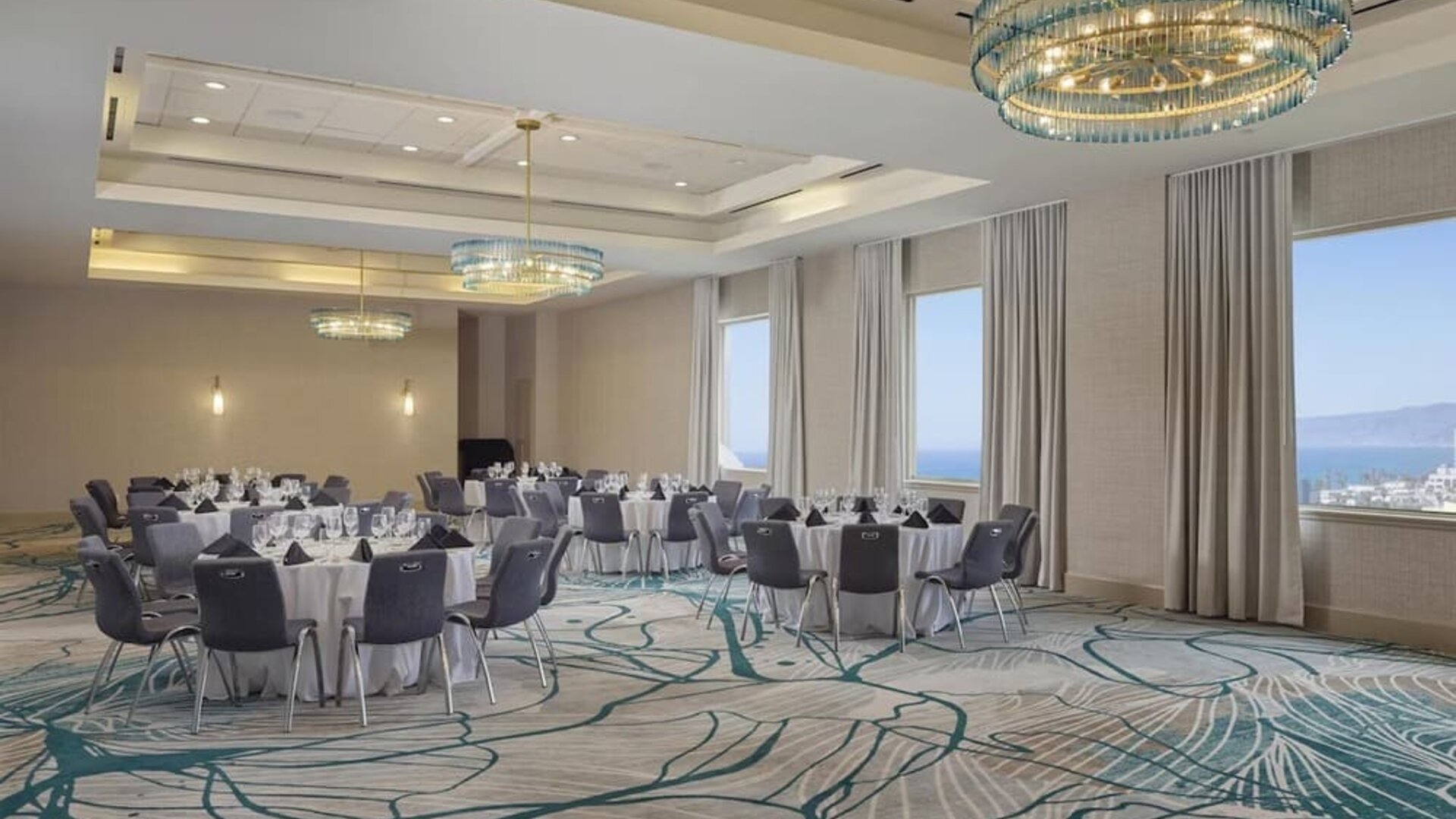 Elegant ballroom with flexible banquet seating, natural light, and modern décor for weddings, conferences, and special events at Hyatt Centric Delfina Santa Monica.