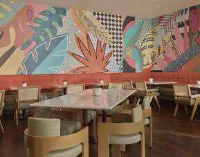 Contemporary hotel dining area with stylish seating, vibrant décor, and an inviting atmosphere for breakfast, lunch, and dinner at Hyatt Centric Delfina Santa Monica.
