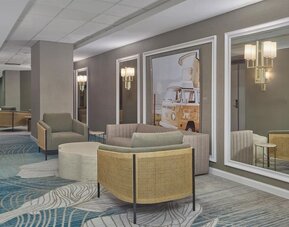 Comfortable lobby lounge with contemporary seating, modern artwork, and welcoming spaces to relax or socialize at Hyatt Centric Delfina Santa Monica.