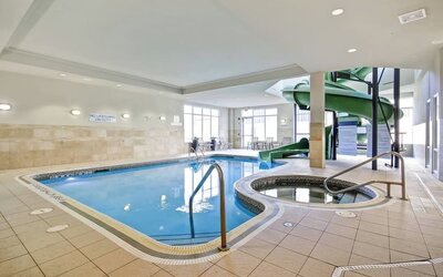 Indoor swimming pool with a hot tub and waterslide for family-friendly recreation at Fairfield Inn & Suites Guelph.