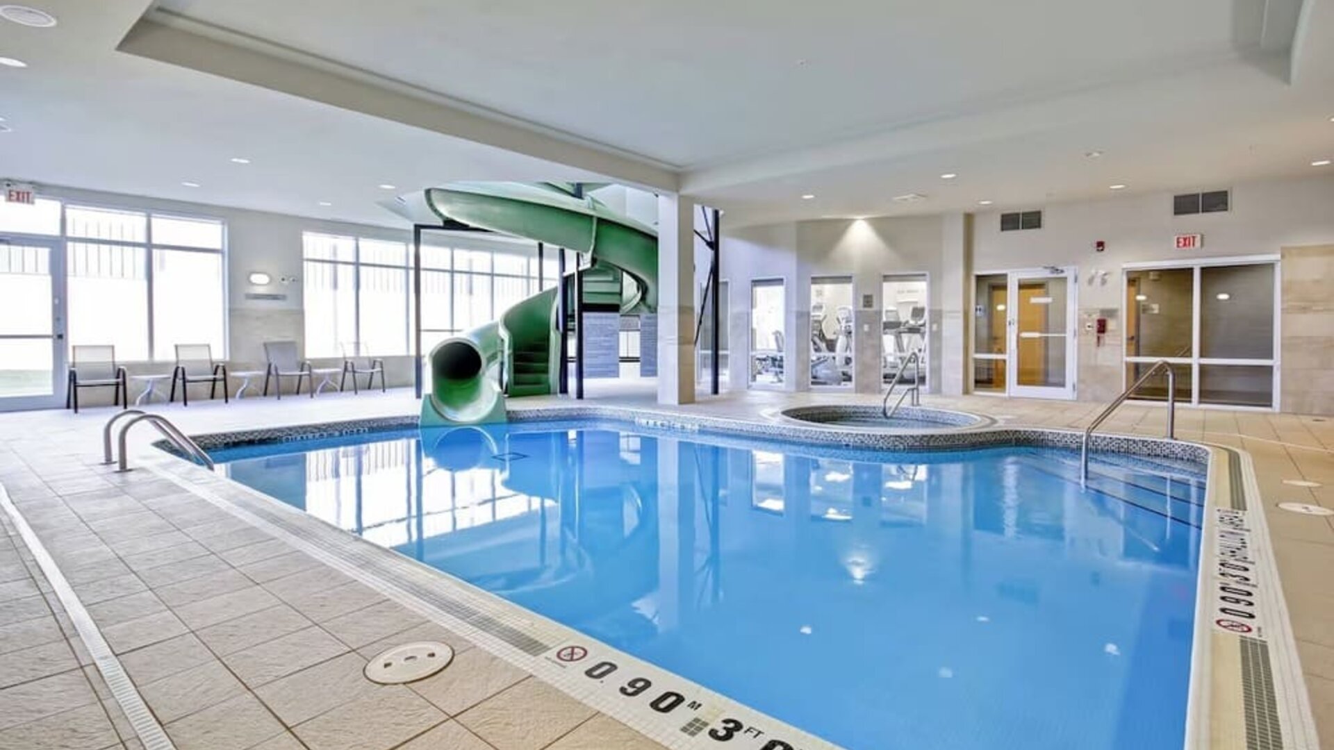 Spacious indoor pool featuring a waterslide, hot tub, and relaxing lounge area at Fairfield Inn & Suites Guelph.