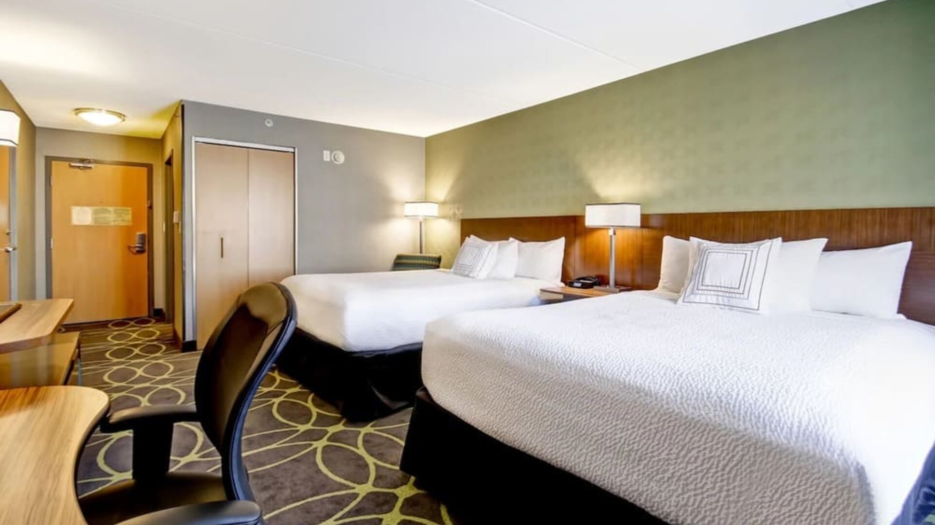 Spacious guest room with two queen beds, work desk, and contemporary furnishings at Fairfield Inn & Suites Guelph.