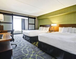 Comfortable guest room featuring two queen beds, modern décor, and convenient in-room workspace at Fairfield Inn & Suites Guelph.