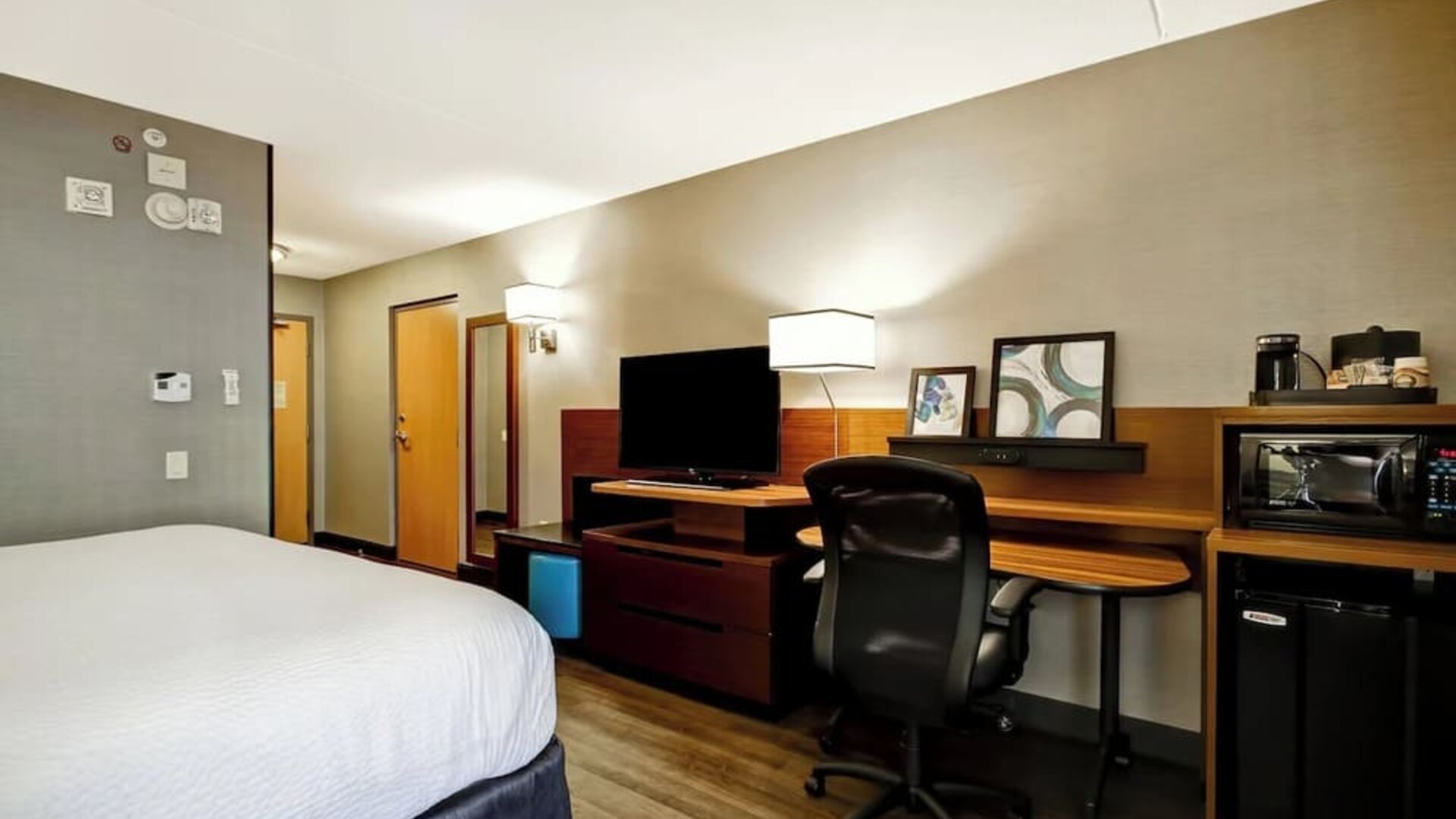 Contemporary king guest room with a spacious work desk, mini fridge, microwave, and flat-screen TV at Fairfield Inn & Suites Guelph.