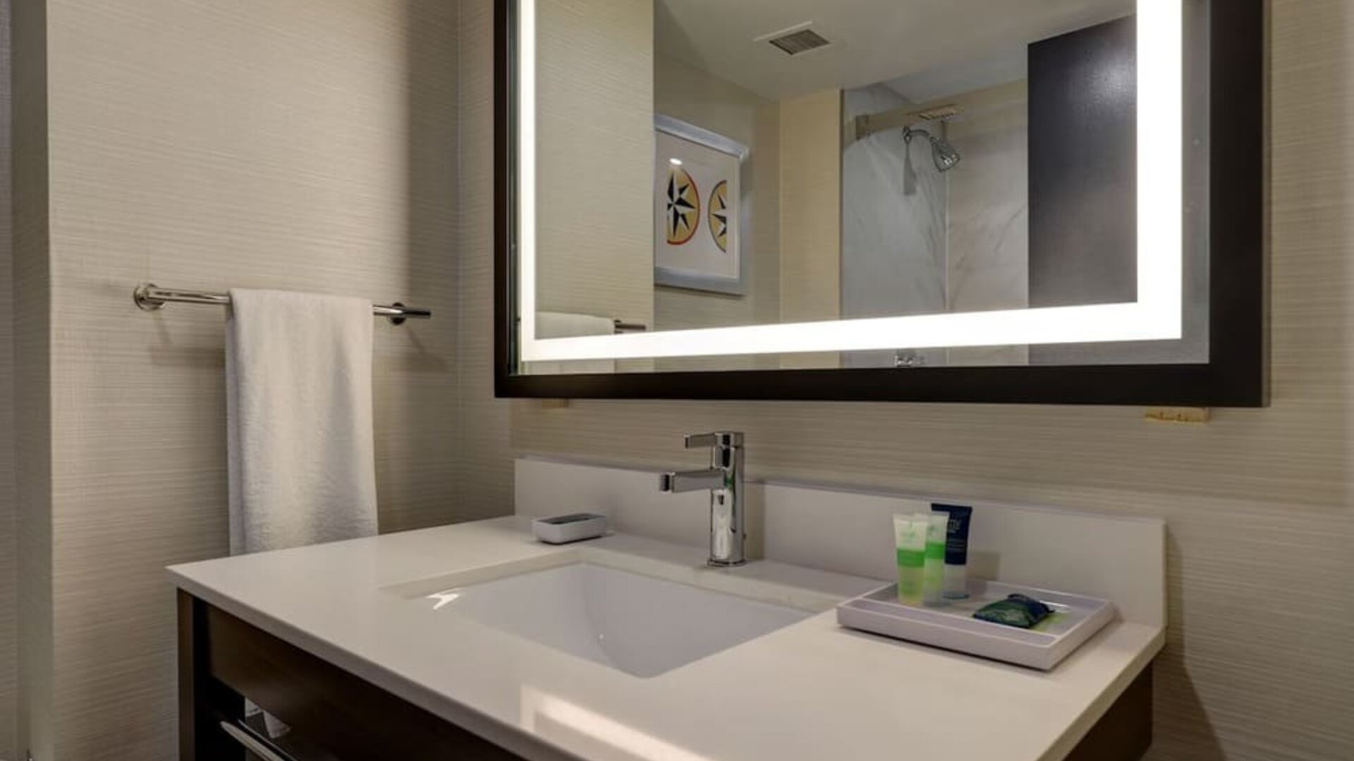 Modern guest bathroom featuring a sleek vanity with illuminated mirror and premium bath amenities at Four Points by Sheraton St. Catharines Niagara Suites.