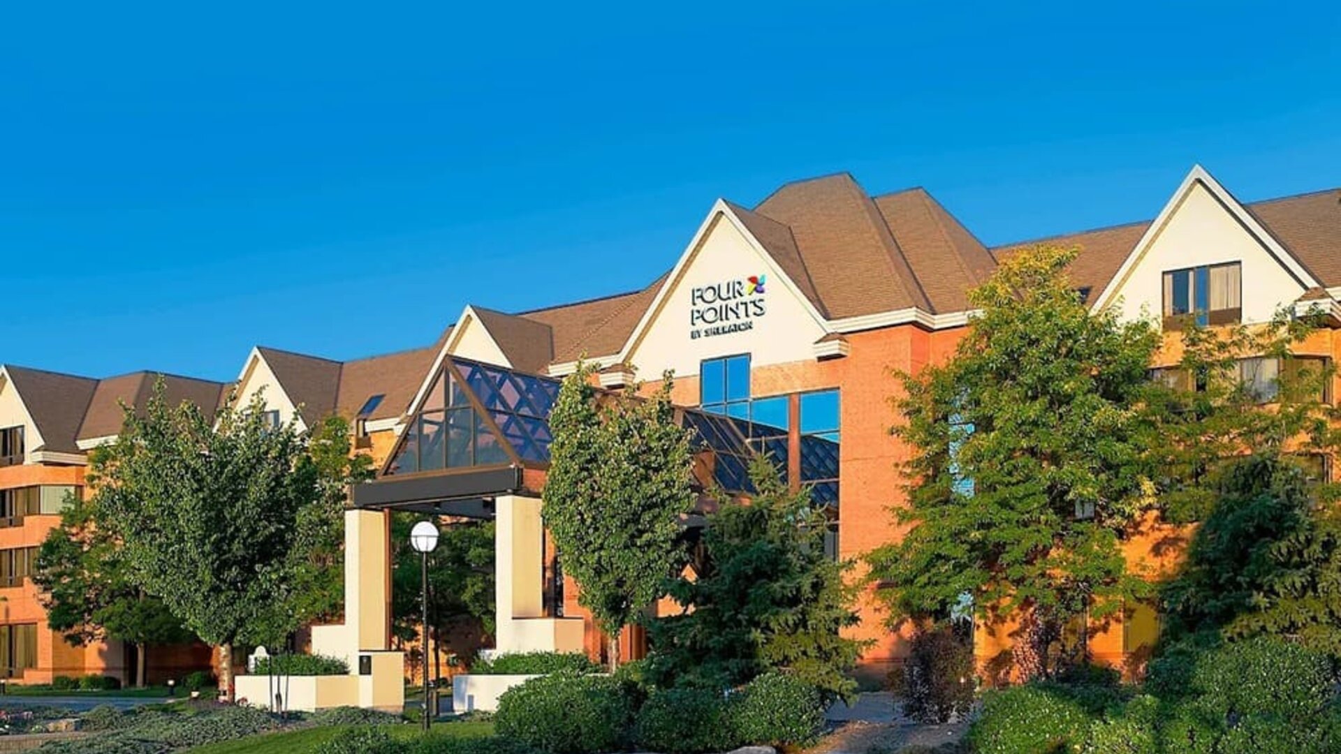 Exterior view of Four Points by Sheraton St. Catharines Niagara Suites with landscaped grounds and welcoming entrance.