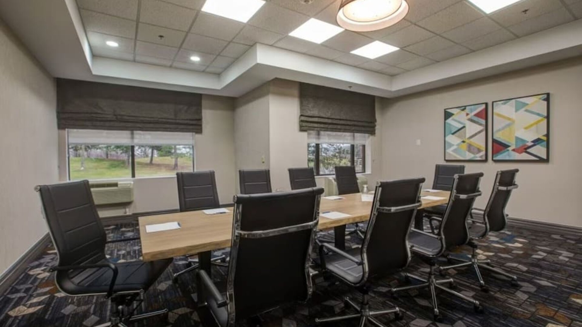 Executive boardroom with modern conference table and comfortable seating at Four Points by Sheraton St. Catharines Niagara Suites.