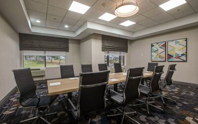Executive boardroom with modern conference table and comfortable seating at Four Points by Sheraton St. Catharines Niagara Suites.