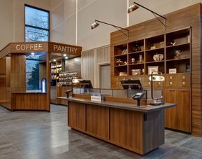 Reception desk with adjacent coffee pantry and convenience market at Four Points by Sheraton St. Catharines Niagara Suites.