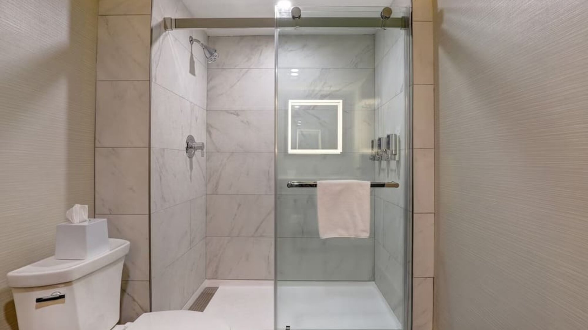 Modern walk-in shower with glass enclosure and premium bath amenities at Four Points by Sheraton St. Catharines Niagara Suites.