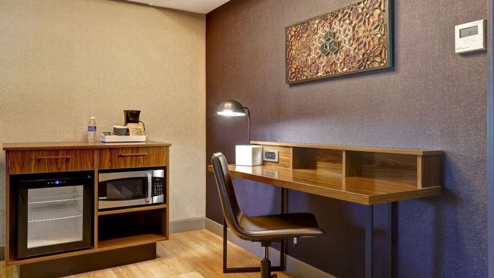 Functional in-room workspace with ergonomic desk, mini refrigerator, microwave, and coffee station at Four Points by Sheraton St. Catharines Niagara Suites.