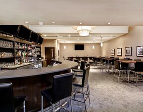 Stylish hotel lounge and bar offering a relaxed setting for cocktails, drinks, and casual gatherings at Holiday Inn Oakville Centre.